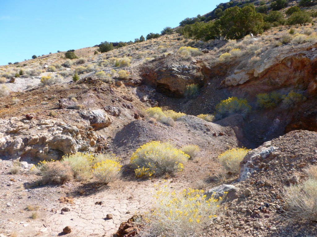 An old mine cut swith small dumps on the west side of Cobb Peak. Bright red oxides mark the silicified reefs. 